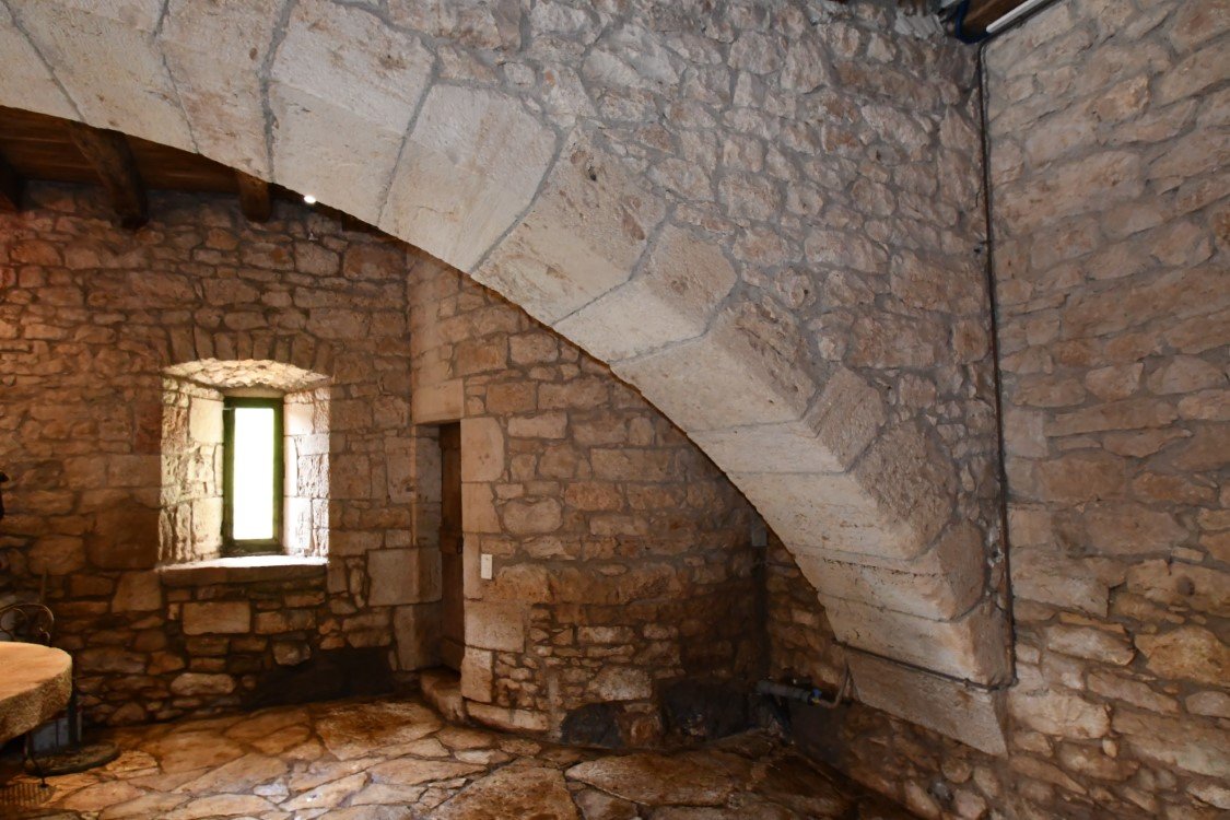 a fine stone arch across the width of a stone room