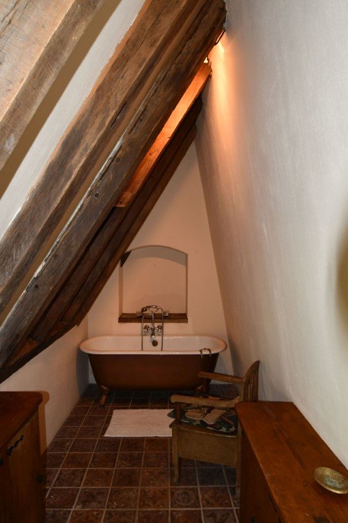 freestanding bath in a bathroom with sliping ceiling