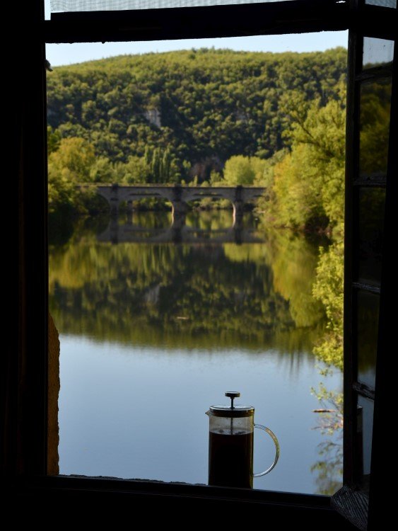 view from narrow window over a river with trees beyond